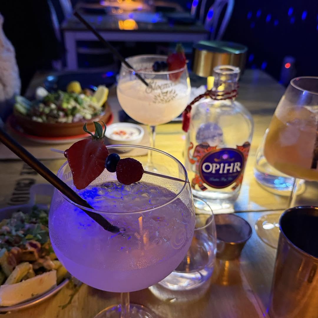 Two gin cocktails garnished with fresh strawberries