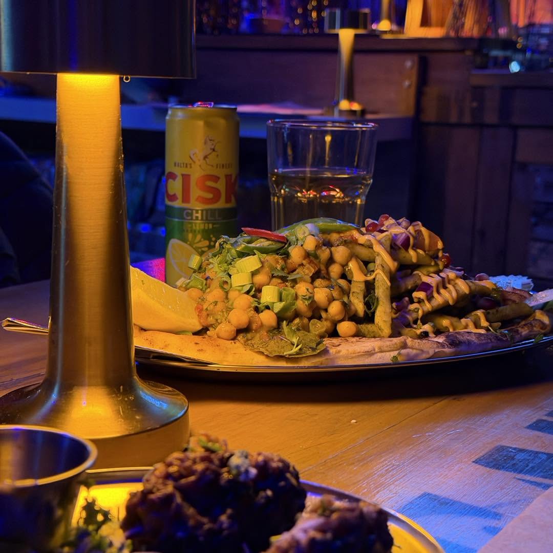 A table spread of loaded naan and cocktails